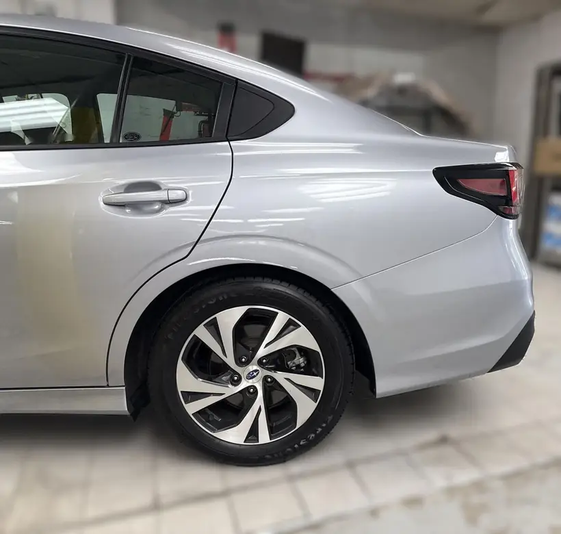 Silver Subaru Legacy rear bumper and quarter panel after collision repair