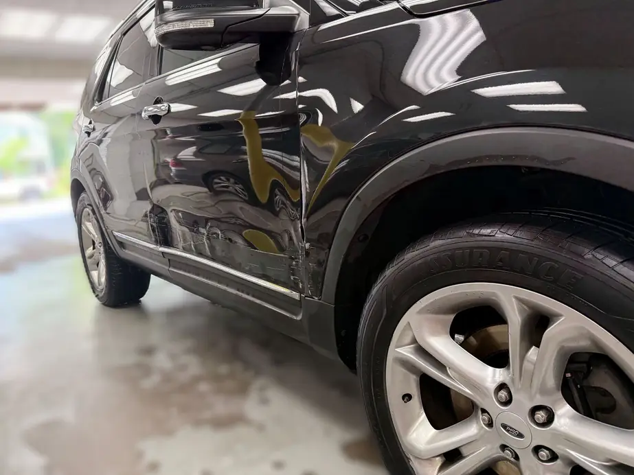 Ford Explorer with a creased door and quarter panel, before repair